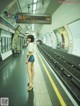 A woman standing in a subway station waiting for the train.