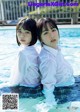 A couple of young women sitting in a swimming pool.