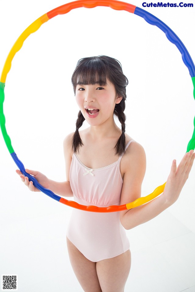 A woman in a pink bathing suit holding a hula hoop.
