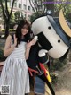 A woman standing next to a giant stuffed animal.