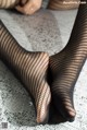 A pair of black fishnet stockings on a woman's legs.